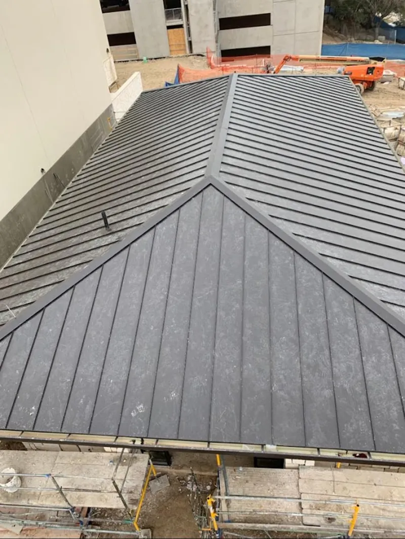 Commercial metal roof construction with crane equipment in Pryor Creek